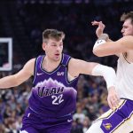 Nov 23, 2025; Salt Lake City, Utah, USA; Utah Jazz forward Kyle Filipowski (22) drives against Los Angeles Lakers guard Luka Doncic (77) during the second half at Delta Center. Mandatory Credit: Rob Gray-Imagn Images