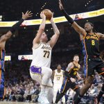 Apr 6, 2025; Oklahoma City, Oklahoma, USA; Los Angeles Lakers guard Luka Doncic (77) drives to the basket between Oklahoma City Thunder guard Shai Gilgeous-Alexander (2) and forward Jalen Williams (8) during the second quarter at Paycom Center. Mandatory Credit: Alonzo Adams-Imagn Images
