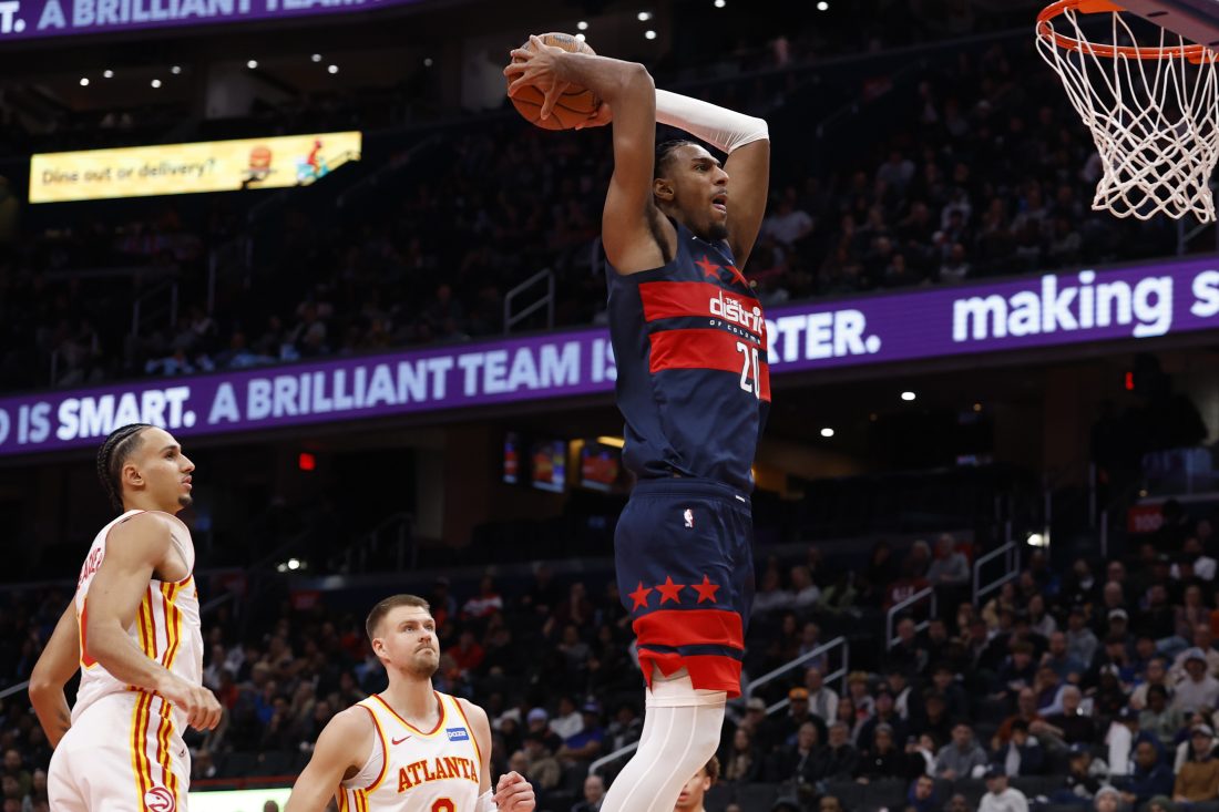 Nov 25, 2025; Washington, District of Columbia, USA; Washington Wizards center Alex Sarr (20) dunks the ball as Atlanta Hawks forward Zaccharie Risacher (10) looks on in the second half at Capital One Arena.