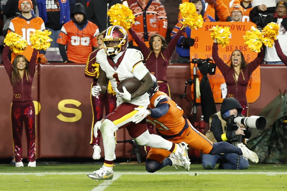 Nov 30, 2025; Landover, Maryland, USA; Washington Commanders wide receiver Deebo Samuel (1) runs with the ball after making a catch as Denver Broncos cornerback Riley Moss (21) defends during overtime at Northwest Stadium. Mandatory Credit: Geoff Burke-Imagn Images