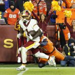 Nov 30, 2025; Landover, Maryland, USA; Washington Commanders wide receiver Deebo Samuel (1) runs with the ball after making a catch as Denver Broncos cornerback Riley Moss (21) defends during overtime at Northwest Stadium. Mandatory Credit: Geoff Burke-Imagn Images