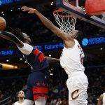 Dec 12, 2025; Washington, District of Columbia, USA; Washington Wizards guard Jamir Watkins (5) dunks the ball as Cleveland Cavaliers center Evan Mobley (4) defends in the first half at Capital One Arena.