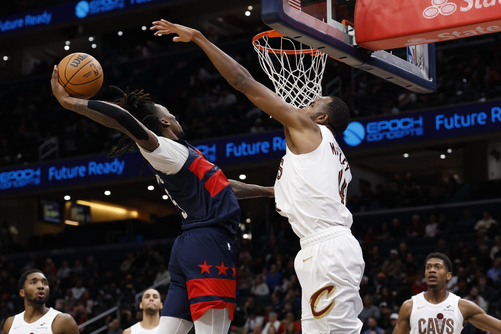 Dec 12, 2025; Washington, District of Columbia, USA; Washington Wizards guard Jamir Watkins (5) dunks the ball as Cleveland Cavaliers center Evan Mobley (4) defends in the first half at Capital One Arena.