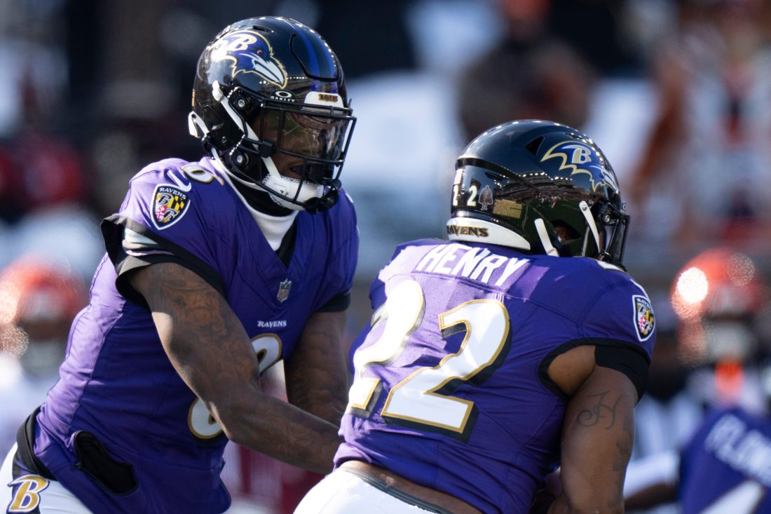 Baltimore Ravens quarterback Lamar Jackson (8) hands off the ball to Baltimore Ravens running back Derrick Henry (22) in the first quarter of the NFL football game at Paycor Stadium in Cincinnati on Dec. 14, 2025.