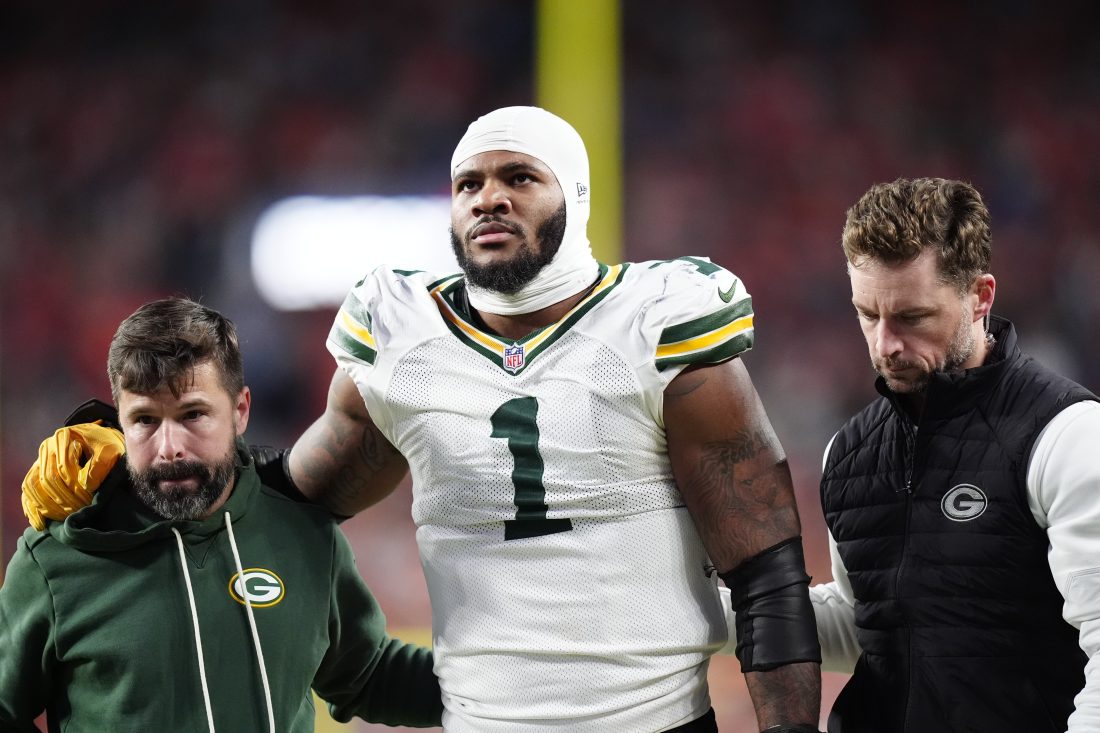 Dec 14, 2025; Denver, Colorado, USA; Green Bay Packers defensive end Micah Parsons (1) walks off the field with help from medical personnel following an injury during the third quarter against the Denver Broncos at Empower Field at Mile High.