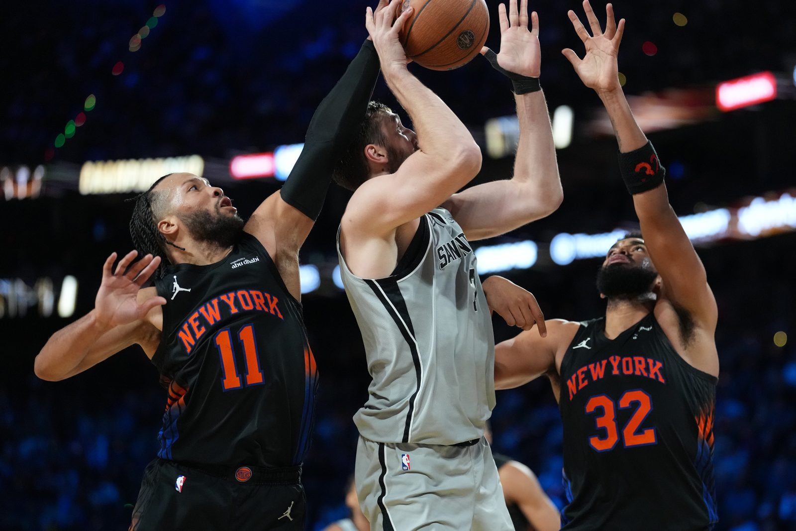 Dec 16, 2025; Las Vegas, Nevada, USA; New York Knicks guard Jalen Brunson (11), center Karl-Anthony Towns (32) attempt to block the shot of San Antonio Spurs center Luke Kornet (7) during the Emirates NBA Cup Final at T-Mobile Arena. Mandatory Credit: Kirby Lee-Imagn Images
