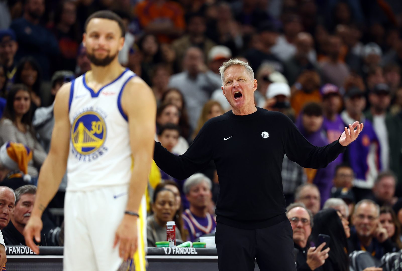 Dec 18, 2025; Phoenix, Arizona, USA; Golden State Warriors guard Stephen Curry (30) reacts alongside head coach Steve Kerr against the Phoenix Suns in the second half at Mortgage Matchup Center.