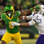 Oregon’s Jordon Davison, left, stiff arms James Madison’s Jacob Thomas for a gain during the second quarter Autzen Stadium in Eugene Dec. 20, 2025.