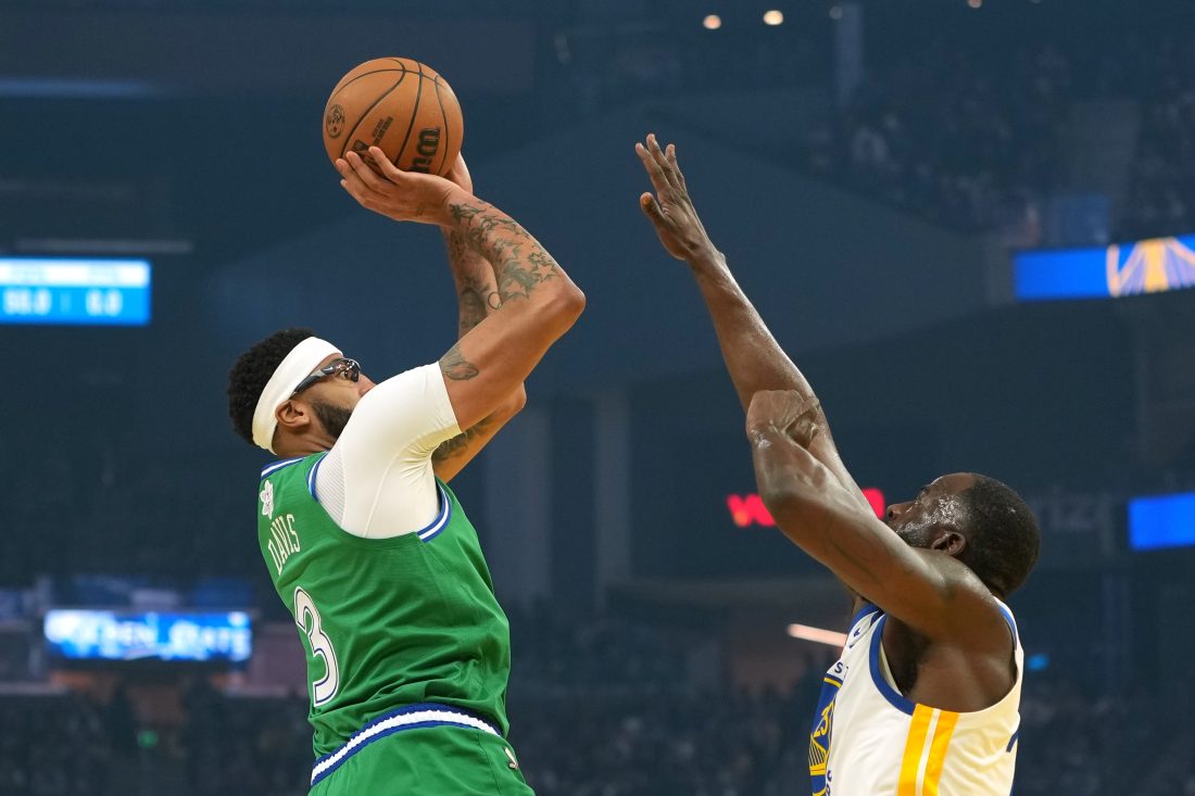 Dec 25, 2025; San Francisco, California, USA; Dallas Mavericks forward Anthony Davis (3) shoots against Golden State Warriors forward Draymond Green (right) during the first quarter at Chase Center.