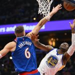 Mar 27, 2022; Washington, District of Columbia, USA; Golden State Warriors forward Jonathan Kuminga (00) shoots as Washington Wizards center Kristaps Porzingis (6) defends during the first half at Capital One Arena. Mandatory Credit: Brad Mills-USA TODAY Sports