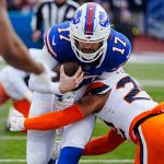 Buffalo Bills quarterback Josh Allen gets tackled by Denver Broncos safety Brandon Jones while carrying the ball during the first half of the Buffalo Bills wild card game against the Denver Broncos at Highmark Stadium in Orchard Park on Jan. 12, 2025.