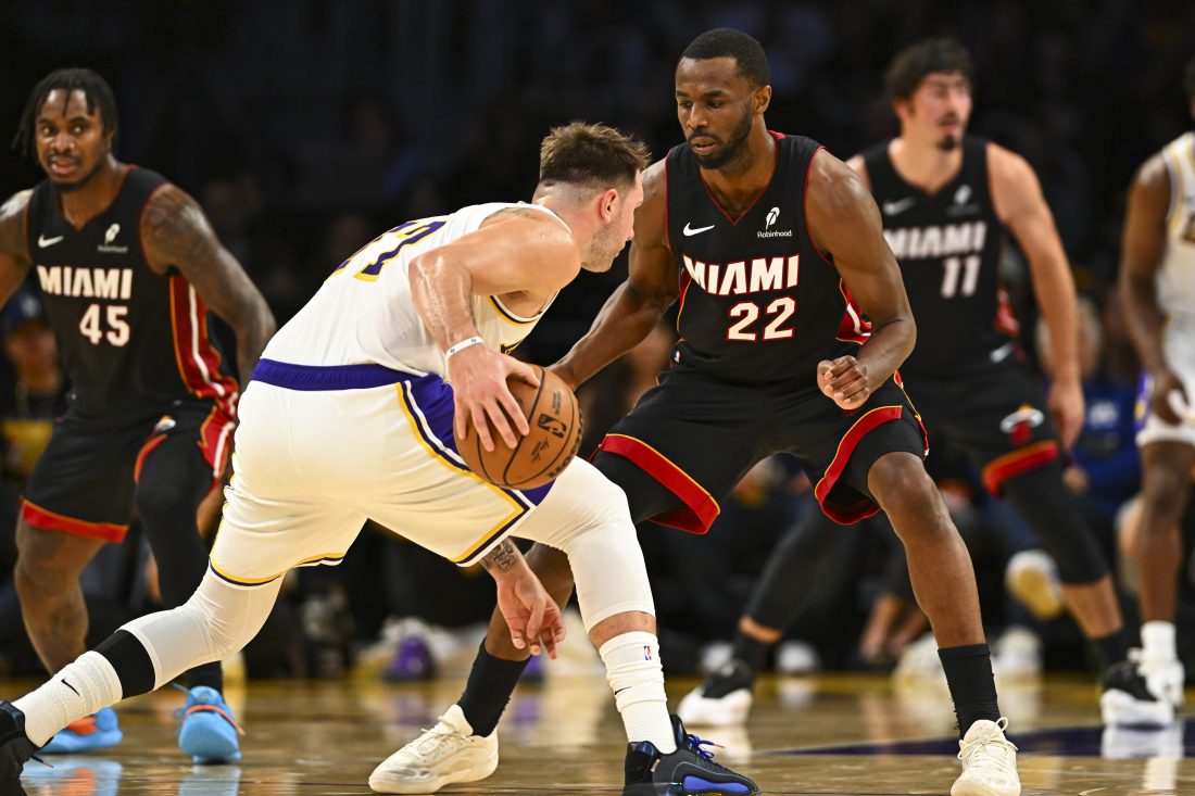 Nov 2, 2025; Los Angeles, California, USA; Los Angeles Lakers guard Luka Dončić (77) moves the ball against Miami Heat forward Andrew Wiggins (22) during the first half at Crypto.com Arena. Mandatory Credit: Jonathan Hui-Imagn Images