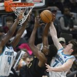 Dec 14, 2025; Cleveland, Ohio, USA; Cleveland Cavaliers forward De'Andre Hunter (12) shoots between Charlotte Hornets guard Sion James (4) and guard Kon Knueppel (7) in the fourth quarter at Rocket Arena. Mandatory Credit: David Richard-Imagn Images