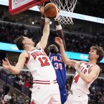 Dec 26, 2025; Chicago, Illinois, USA; Chicago Bulls forward Zach Collins (12) defends Philadelphia 76ers center Adem Bona (30) during the second half at United Center.