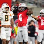 Ohio State Buckeyes wide receiver Jeremiah Smith (4) celebrates a first down beside Miami Hurricanes defensive back Jakobe Thomas (8) during the Cotton Bowl at AT&T Stadium in Arlington, Texas for the College Football Playoff quarterfinal game on Dec. 31, 2025. Ohio State lost 24-14.