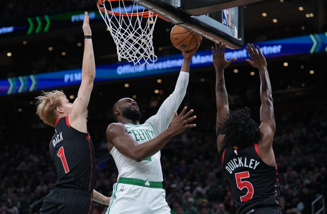 Jan 9, 2026; Boston, Massachusetts, USA; Boston Celtics guard Jaylen Brown (7) drives to the basket against Toronto Raptors guard Immanuel Quickley (5) and guard Gradey Dick (1) in the first quarter at TD Garden. Mandatory Credit: David Butler II-Imagn Images