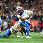 an 11, 2026; Foxborough, MA, USA; Los Angeles Chargers quarterback Justin Herbert (10) is sacked by New England Patriots linebacker Anfernee Jennings (33) during the fourth quarter against the New England Patriotsin an AFC Wild Card Round game at Gillette Stadium.