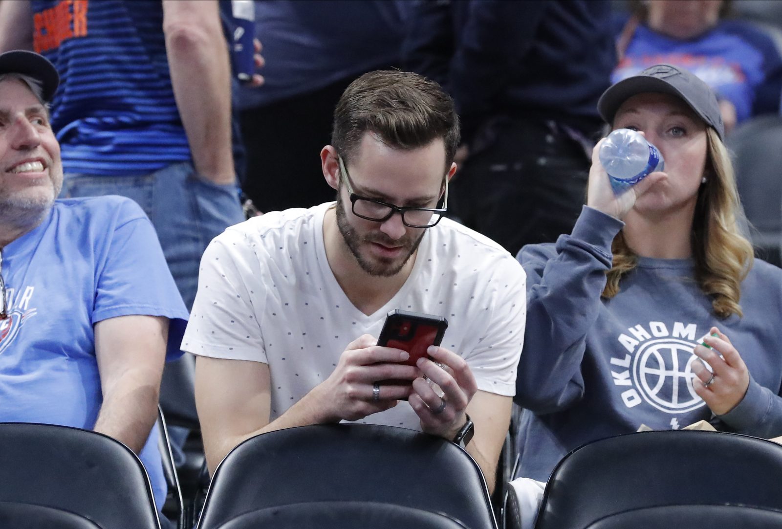 Mar 11, 2020; Oklahoma City, Oklahoma, USA; A fan looks at his phone while waiting on an announcement at the Utah Jazz Oklahoma City Thunder game at Chesapeake Energy Arena after both teams were sent to their locker rooms. Mandatory Credit: Alonzo Adams-USA TODAY Sports