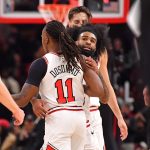 Feb 28, 2025; Chicago, Illinois, USA; Chicago Bulls guard Coby White (behind) hugs guard Ayo Dosunmu (11) during overtime against the Toronto Raptors at the United Center. Mandatory Credit: Patrick Gorski-Imagn Images
