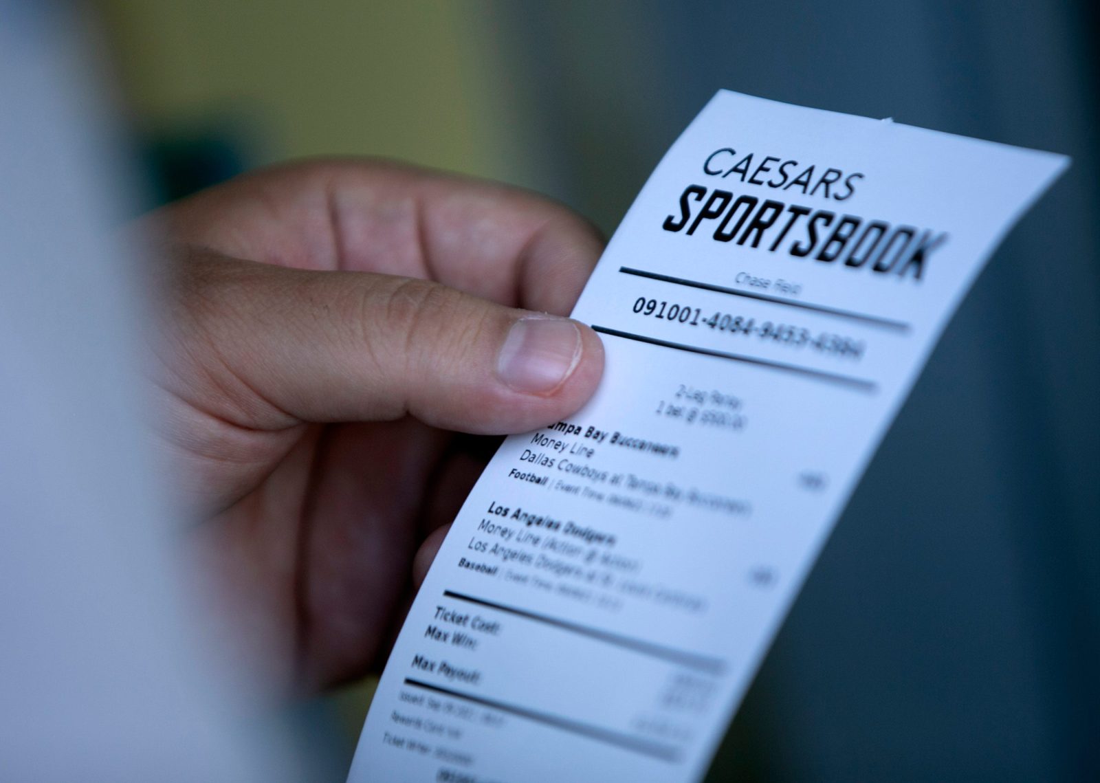 A man looks at his ticket after placing a bet at the Caesars Sportsbook betting window at Chase Field in Phoenix on the first day of sports betting on September 9, 2021. Chase Field is the first major league stadium to have sports betting.