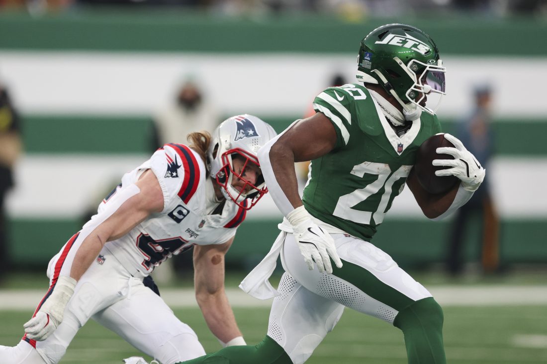 Dec 28, 2025; East Rutherford, New Jersey, USA; New York Jets running back Breece Hall (20) runs for a touchdown against New England Patriots safety Brenden Schooler (41) during the second half of the game at MetLife Stadium. Mandatory Credit: