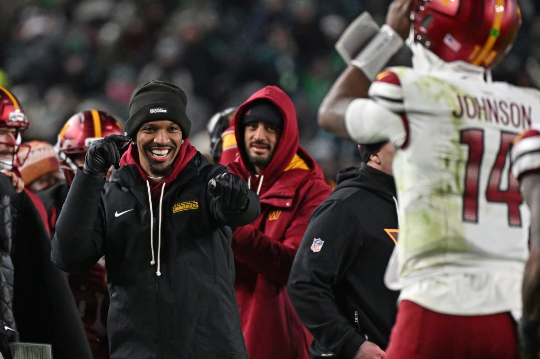 Jan 4, 2026; Philadelphia, Pennsylvania, USA; Washington Commanders quarterback Jayden Daniels (5) celebrates touchdown run by quarterback Josh Johnson (14) during the fourth quarter against the Philadelphia Eagles at Lincoln Financial Field. Mandatory Credit: