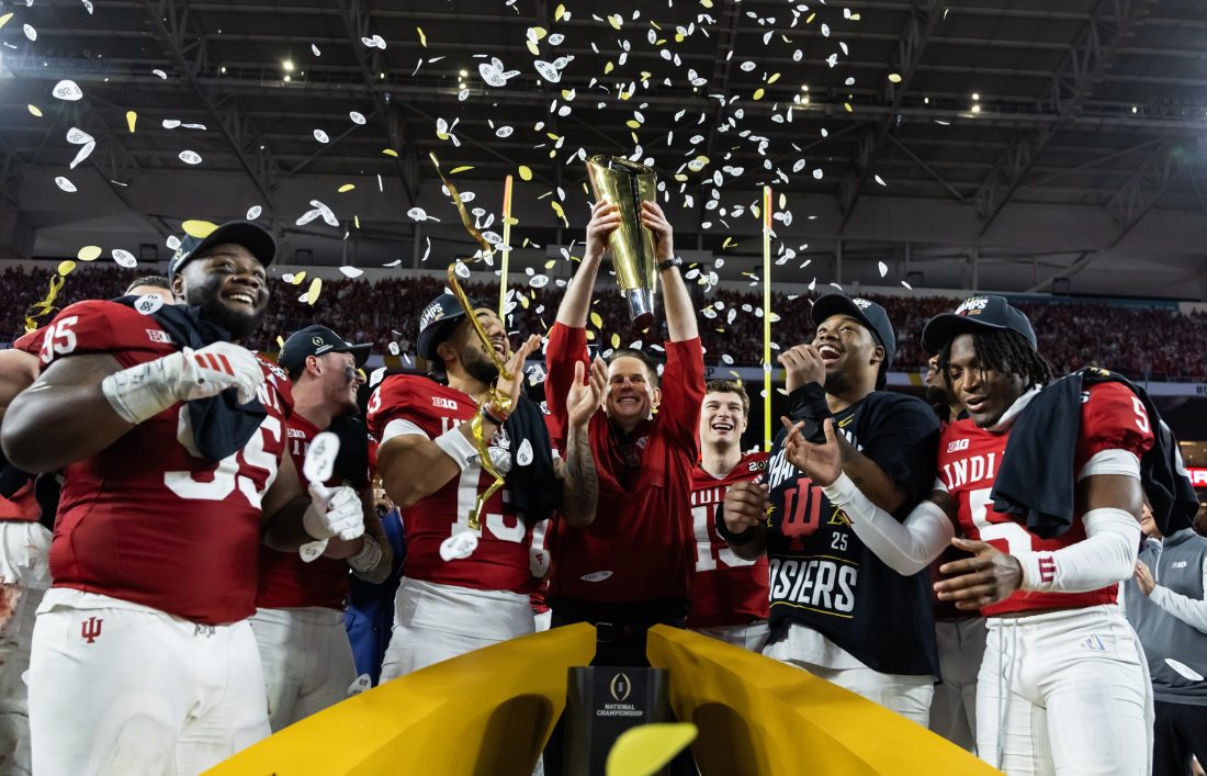 Jan 19, 2026; Miami Gardens, FL, USA; Indiana Hoosiers head coach Curt Cignetti hoists the trophy as he celebrates with defensive lineman Tyrique Tucker (95), wide receiver Elijah Sarratt (13), quarterback Fernando Mendoza (16), defensive lineman Mikail Kamara and defensive back D'Angelo Ponds (5) after defeating the Miami Hurricanes in the College Football Playoff National Championship game at Hard Rock Stadium.