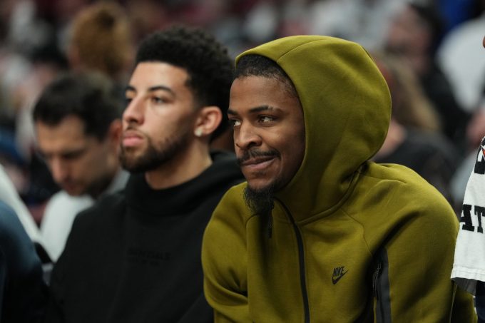 Feb 7, 2026; Portland, Oregon, USA; Memphis Grizzlies guards Scotty Pippen Jr. (1, left) and Ja Morant (12) watch from the bench during the first half against the Portland Trail Blazers at Moda Center.