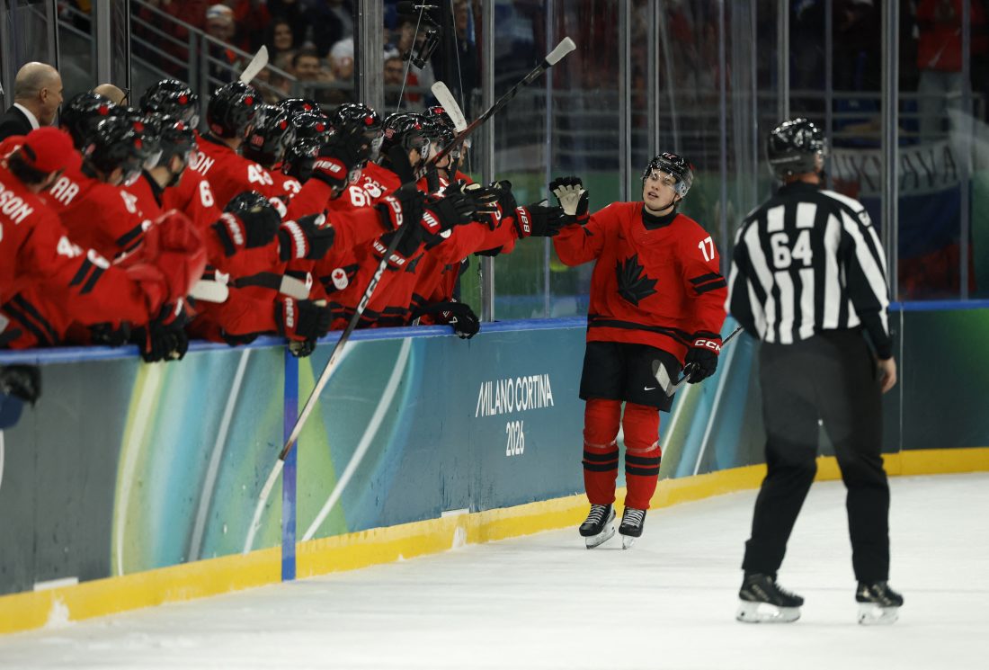 Feb 15, 2026; Milan, Italy; Macklin Celebrini of Canada celebrates scoring their fifth goal with teammates against France in men's ice hockey group A play during the Milano Cortina 2026 Olympic Winter Games at Milano Santagiulia Ice Hockey Arena. Mandatory Credit:
