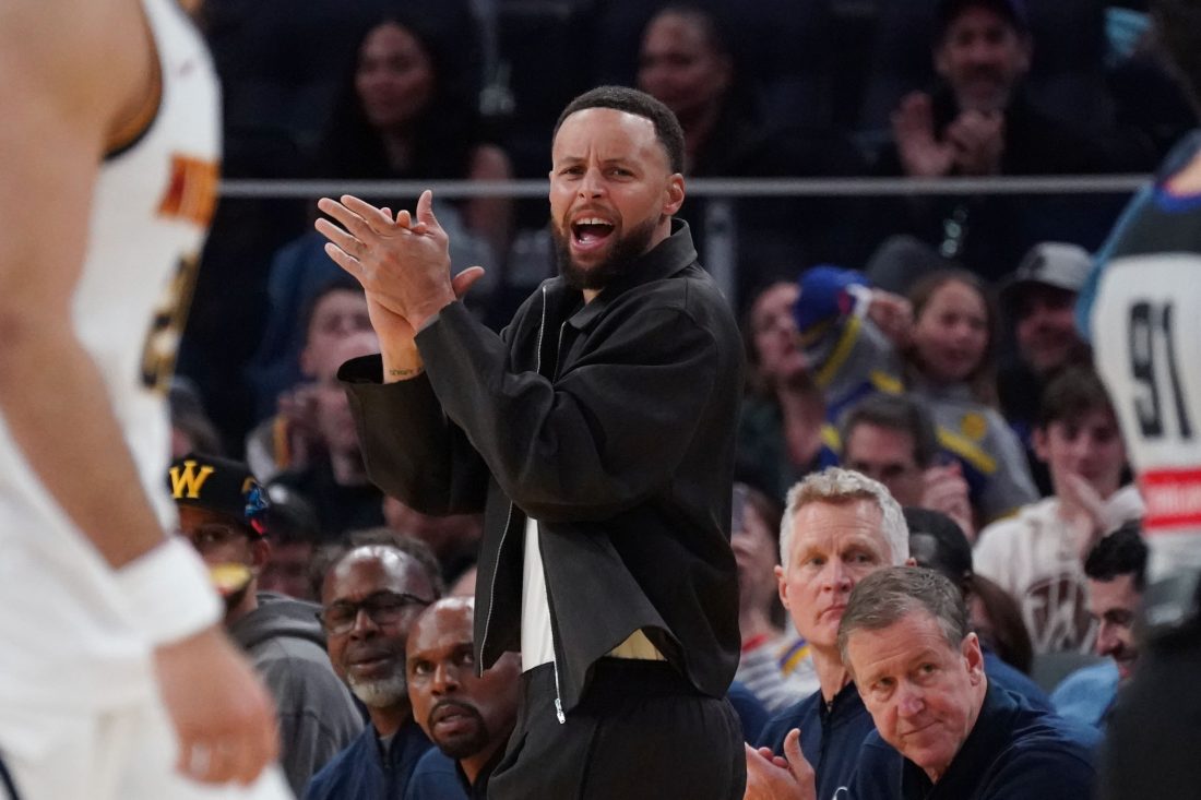 Feb 22, 2026; San Francisco, California, USA; Golden State Warriors guard Stephen Curry (30) cheers from the bench during a game against the Denver Nuggets in the third quarter at Chase Center.