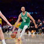 Feb 22, 2026; Los Angeles, California, USA; Boston Celtics guard Derrick White (9) moves the ball against Los Angeles Lakers forward Jake LaRavia (12) and forward Rui Hachimura (28) during the first half at Crypto.com Arena. Mandatory Credit: