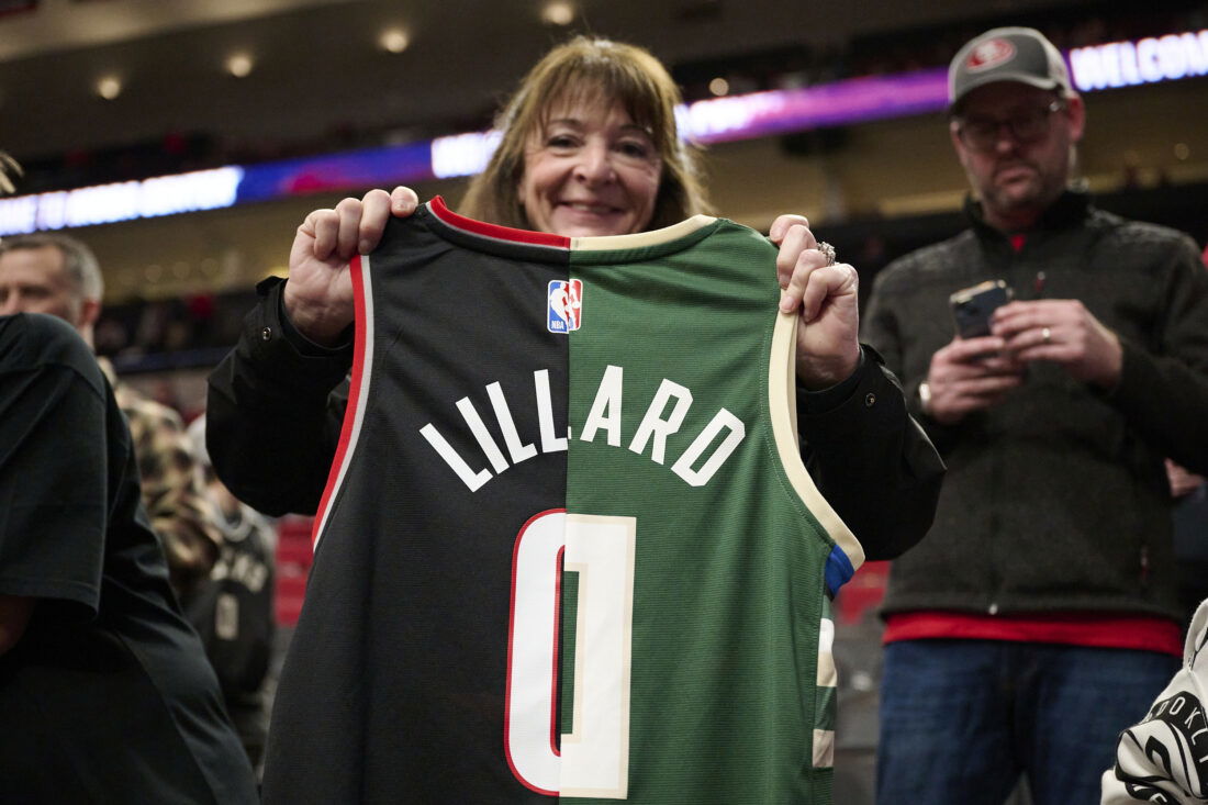 Jan 31, 2024; Portland, Oregon, USA; A basketball fan holds a jersey with the colors and number of the Portland Trail Blazers and Milwaukee Bucks guard Damian Lillard (0) at Moda Center. Mandatory Credit: Troy Wayrynen-USA TODAY Sports