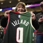 Jan 31, 2024; Portland, Oregon, USA; A basketball fan holds a jersey with the colors and number of the Portland Trail Blazers and Milwaukee Bucks guard Damian Lillard (0) at Moda Center. Mandatory Credit: Troy Wayrynen-USA TODAY Sports