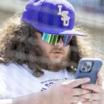 May 26, 2024; Hoover, AL, USA; A fan checks his phone during the championship game between Tennessee and LSU at the SEC Baseball Tournament at Hoover Metropolitan Stadium. Mandatory Credit: Vasha Hunt-USA TODAY Sports