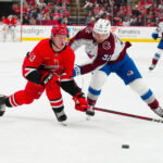 Dec 5, 2024; Raleigh, North Carolina, USA; Colorado Avalanche right wing Nikolai Kovalenko (51) checks Carolina Hurricanes right wing Jackson Blake (53) during the third period at Lenovo Center. Mandatory Credit: James Guillory-Imagn Images