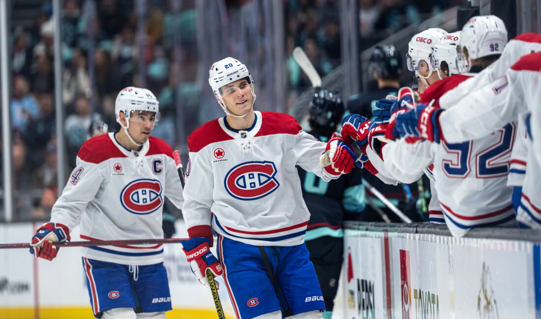 Mar 12, 2025; Seattle, Washington, USA; Montreal Canadiens forward Juraj Slafkovský (20) and forward Nick Suzuki (14), left, celebrate a goal against the Seattle Kraken with teammates on the bench during the third period at Climate Pledge Arena. Mandatory Credit: Stephen Brashear-Imagn Images