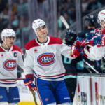 Mar 12, 2025; Seattle, Washington, USA; Montreal Canadiens forward Juraj Slafkovský (20) and forward Nick Suzuki (14), left, celebrate a goal against the Seattle Kraken with teammates on the bench during the third period at Climate Pledge Arena. Mandatory Credit: Stephen Brashear-Imagn Images