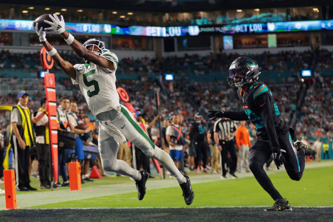 Sep 29, 2025; Miami Gardens, Florida, USA; New York Jets wide receiver Garrett Wilson (5) attempts to make a catch against Miami Dolphins cornerback Artie Burns (23) during the second half at Hard Rock Stadium. Mandatory Credit: Sam Navarro-Imagn Images