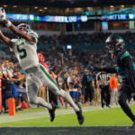 Sep 29, 2025; Miami Gardens, Florida, USA; New York Jets wide receiver Garrett Wilson (5) attempts to make a catch against Miami Dolphins cornerback Artie Burns (23) during the second half at Hard Rock Stadium. Mandatory Credit: Sam Navarro-Imagn Images