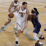 Feb 27, 2026; Oklahoma City, Oklahoma, USA; Denver Nuggets center Nikola Jokić (15) drives against Oklahoma City Thunder guard Luguentz Dort (5) during the second quarter at Paycom Center. Mandatory Credit: Alonzo Adams-Imagn Images