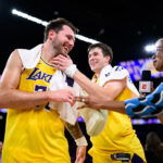 Mar 14, 2026; Los Angeles, California, USA; Los Angeles Lakers guard Luka Doncic (77) reacts with guard Austin Reaves (15) after scoring a game winning shot during overtime against the Denver Nuggets at Crypto.com Arena. Mandatory Credit: William Liang-Imagn Images
