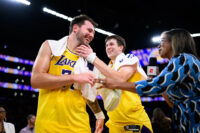Mar 14, 2026; Los Angeles, California, USA; Los Angeles Lakers guard Luka Doncic (77) reacts with guard Austin Reaves (15) after scoring a game winning shot during overtime against the Denver Nuggets at Crypto.com Arena. Mandatory Credit: William Liang-Imagn Images