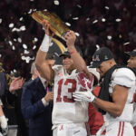 Jan 8, 2018; Atlanta, GA, USA; Alabama Crimson Tide quarterback Tua Tagovailoa (13) holds up the trophy after the win over the Georgia Bulldogs in the 2018 CFP national championship college football game at Mercedes-Benz Stadium.
