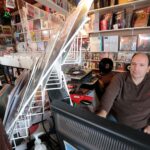 Joao Pimentel, owner, checks online sales on his computer at Max J Records on Bridge Street in Fairhaven.
