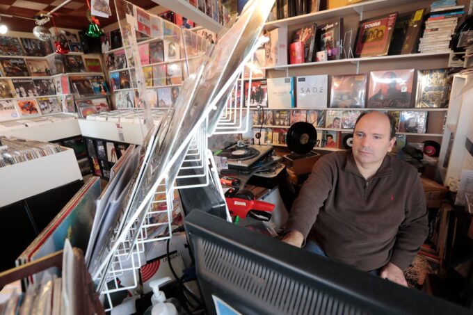 Joao Pimentel, owner, checks online sales on his computer at Max J Records on Bridge Street in Fairhaven.