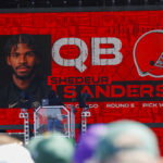 Apr 25, 2025; Green Bay, WI, USA; A graphic announcing Colorado quarterback Shedeur Sanders’ selection by the Cleveland Browns with the 144th overall pick is seen in the Draft Theater during the third day of the 2025 NFL Draft at Lambeau Field. Mandatory Credit: Tork Mason/USA Today Network via Imagn Images
