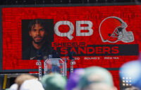Apr 25, 2025; Green Bay, WI, USA; A graphic announcing Colorado quarterback Shedeur Sanders’ selection by the Cleveland Browns with the 144th overall pick is seen in the Draft Theater during the third day of the 2025 NFL Draft at Lambeau Field. Mandatory Credit: Tork Mason/USA Today Network via Imagn Images