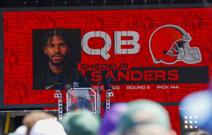 Apr 25, 2025; Green Bay, WI, USA; A graphic announcing Colorado quarterback Shedeur Sanders’ selection by the Cleveland Browns with the 144th overall pick is seen in the Draft Theater during the third day of the 2025 NFL Draft at Lambeau Field. Mandatory Credit: Tork Mason/USA Today Network via Imagn Images