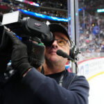 May 1, 2025; Denver, Colorado, USA; Altitude in house TV broadcaster Jim Huck films during the third period between the Dallas Stars against the Colorado Avalanchein game six of the first round of the 2025 Stanley Cup Playoffs at Ball Arena. Mandatory Credit: Ron Chenoy-Imagn Images