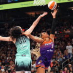 Sep 19, 2025; Phoenix, Arizona, USA; Phoenix Mercury forward Satou Sabally (0) shoots over New York Liberty forward Breanna Stewart (30) during the second half of game three of round one for the 2025 WNBA Playoffs at PHX Arena. Mandatory Credit: Joe Camporeale-Imagn Images